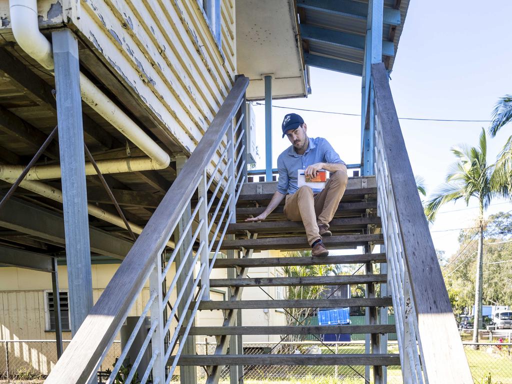 Courier-Mail reporter, Matty Holdsworth, on the stairs of a Tramore Street home, which was smashed by floods. The water level crept up to the third highest step. Picture: Matthew Poon.