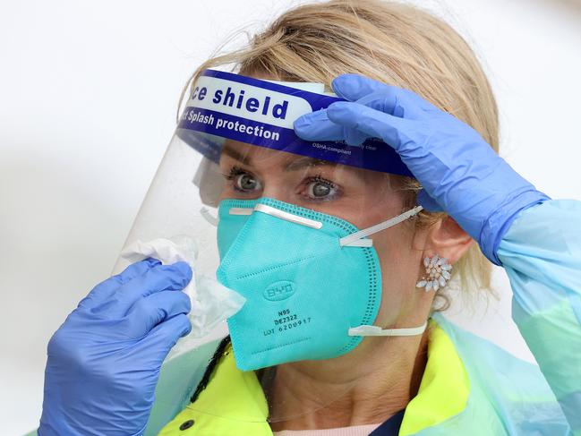 SYDNEY, AUSTRALIA - NewsWire Photos October 25, 2020: Pictured: Wearing rain gear is Registered Nurse Francee Drew wiping the rain off of her face shield at St VincentÃs Hospital Bondi Beach Covid testing site in Sydney, NSW. Picture: NCA NewsWire / Dylan Coker