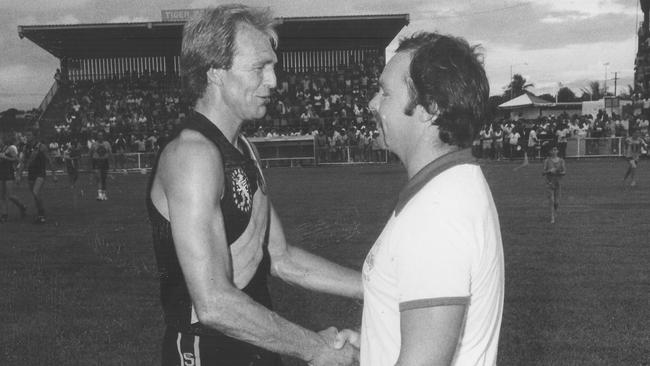 Glenelg captain Graham Cornes congratulates NTFL coach John Taylor at an interstate match at Gardens in January, 1985.