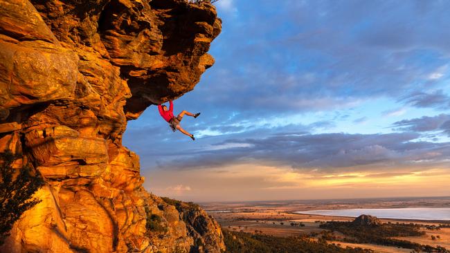 A free climber Tom Perkins swings out on a climb near the summit of Mount Arapiles. Picture: Jason Edwards