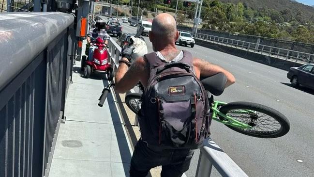 A man on a mobility scooter was forced to reverse for 15 minutes in order to let a cargo bike past on one of the Tasman Bridge pathways due to how narrow they are. Other users of the pathway had no choice but to lift their bikes over the railing so they themselves could pass. Picture: Supplied