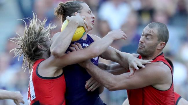 Nat Fyfe of the Dockers, centre, cops some heavy attention during Fremantle’s win against Essendon. Picture: AAP Image/Richard Wainwright