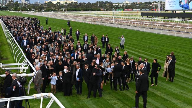 Mourners on the famous Flemington straight at the service.