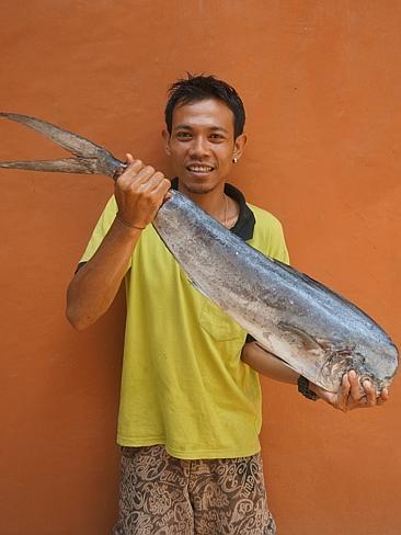 The waiter holds up the red snapper special before lunch. 