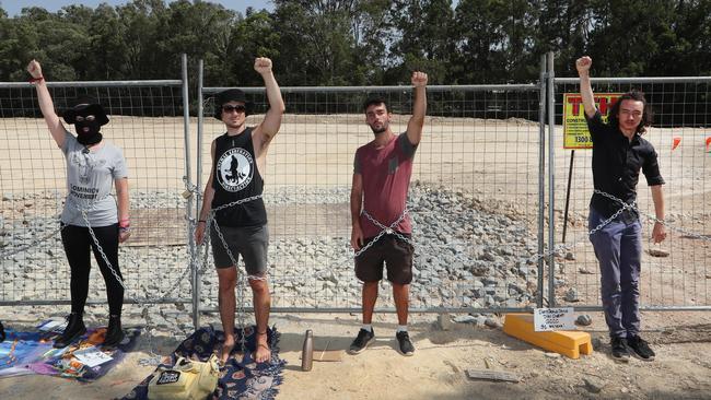 Black Swan Lake protest at Bundall goes to another level, with protesters chaining themselves to the fence and then getting themselves arrested after running onto the worksite and stopping the trucks. Protesters chained to the fence. Picture Glenn Hampson