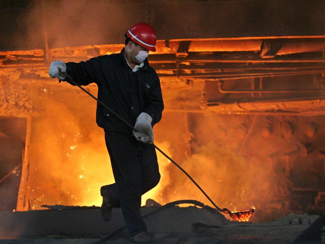 A steel factory worker handles molten steel at the Bao Gang (or Baotou Iron and Steel) Steelworks in Baotou, Inner Mongolia, China Aug 18 2005 : PicNatalie/Behring /Bloomberg /News - industry o/seas