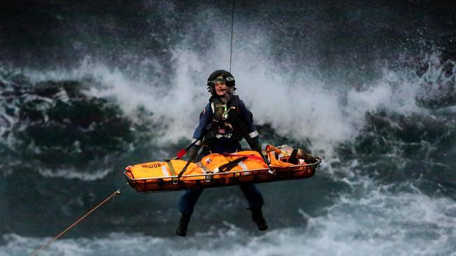 Blake Hayes is flown from the cliff base below Turimetta head. Picture: Adam Ward