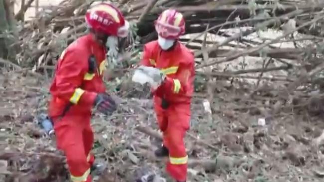 Recovery workers search the crash site on Monday. Picture: CCTV via AFP