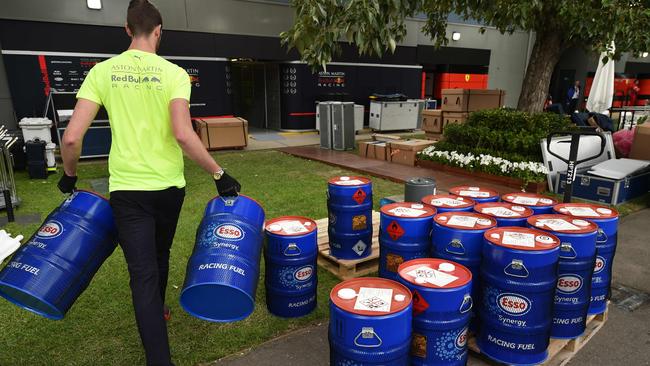 A member of the Red Bull Racing team removes fuel canisters after the Australian Grand Prix was cancelled. Picture: Peter Parks