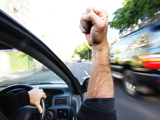 Generic pic of a motorist inside his car as he shakes his fist at passing vehicles.