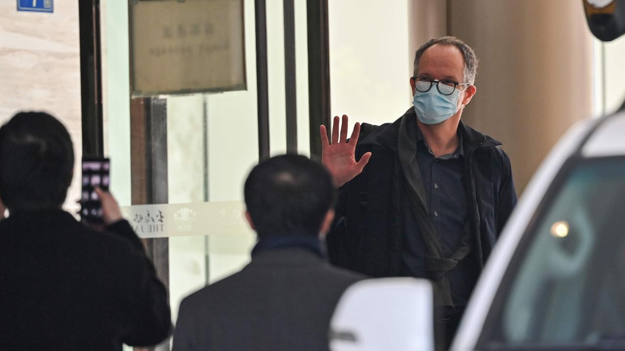 One of the members of the World Health Organisation (WHO) team waves as he leaves The Jade Hotel after completing quarantine in Wuhan. Picture: Hector Retamal