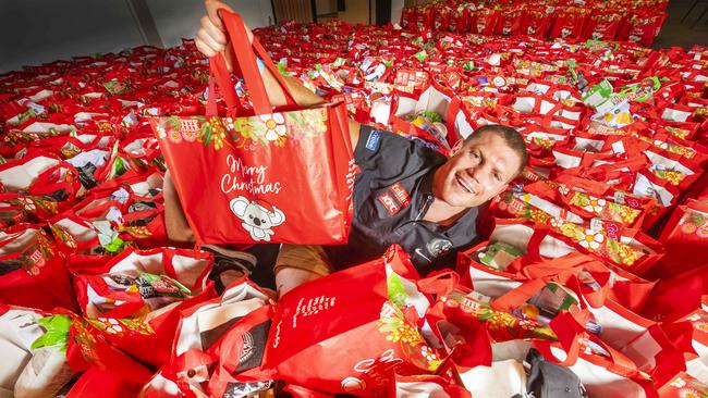 Collingwood FC midfielder and vice-captain Taylor Adams among Coles Christmas hampers and presents for a traditional Christmas Day luncheon for Melburnians in need. Picture: Rob Leeson