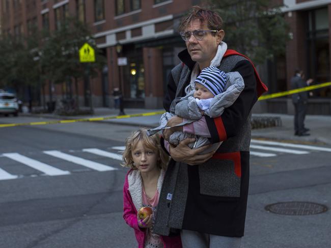 A father reacts as he carries his children out of the crime scene. Picture: AP