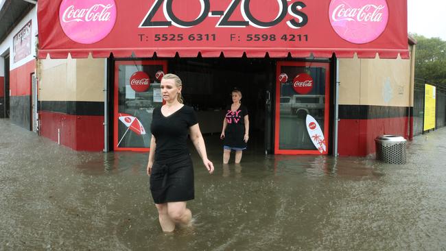 Major flooding in Currumbin Creek rd at Currumbin. Mel Tiesman and Sue Earmell from ZO-ZO's takeaway look on helplessly as floodwater inundates their store. Picture: Glenn Hampson