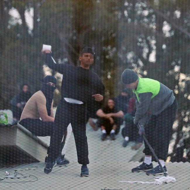 Inmates from the Frank Baxter Juvenile corrections centre Kariong taunt police from the roofs of various buildings. Some are armed with poles tennis rackets ect. Picture: John Grainger