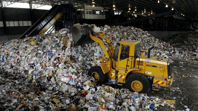 A bulldozer heaps recycling at an Australian rubbish depot.