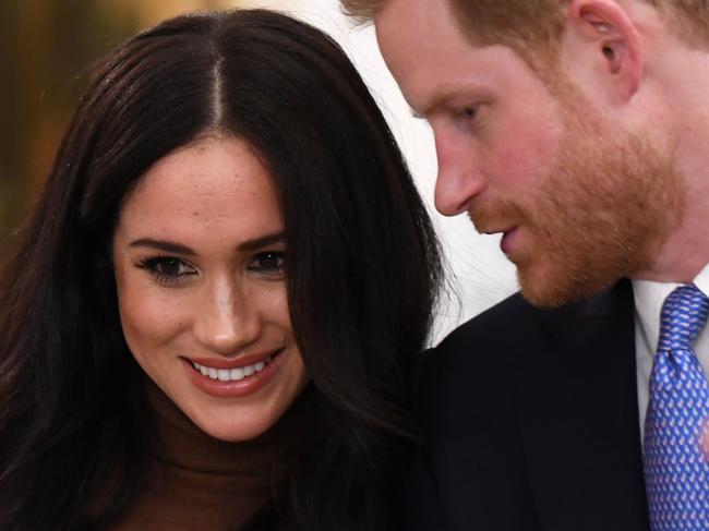 (FILES) In this file photo taken on January 07, 2020 Britain's Prince Harry, Duke of Sussex and Meghan, Duchess of Sussex react during their visit to Canada House in thanks for the warm Canadian hospitality and support they received during their recent stay in Canada,  in London. - Britain's Prince Harry and his wife Meghan will give up their titles and stop receiving public funds following their decision to give up front-line royal duties, Buckingham Palace said on January 18, 2020. "The Sussexes will not use their HRH titles as they are no longer working members of the Royal Family," the Palace said, adding that the couple have agreed to repay some past expenses. (Photo by DANIEL LEAL-OLIVAS / various sources / AFP)