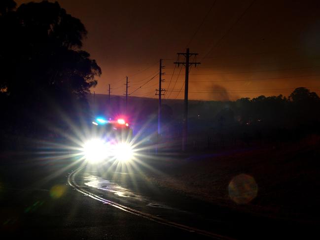 An emergency services vehicle drives with its lights on as the afternoon sky glows orange from bushfires in the area around the town of Nowra in the Australian state of New South Wales on December 31, 2019. - Thousands of holidaymakers and locals were forced to flee to beaches in fire-ravaged southeast Australia on December 31, as blazes ripped through popular tourist areas leaving no escape by land. Picture: Saeed Khan/AFP