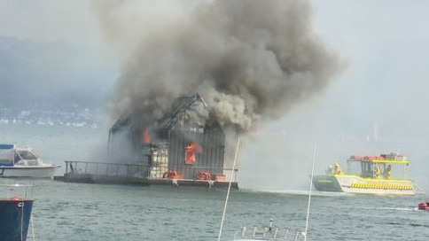 Fireys took to the water to try and save the houseboat but it was destroyed. Picture: TNV