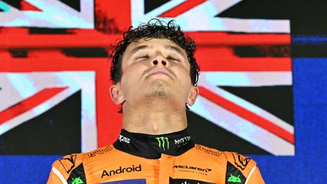 McLaren's British driver Lando Norris reacts on the podium as he celebrates winning the Formula One Singapore Grand Prix night race at the Marina Bay Street Circuit in Singapore on September 22, 2024. (Photo by MOHD RASFAN / AFP)