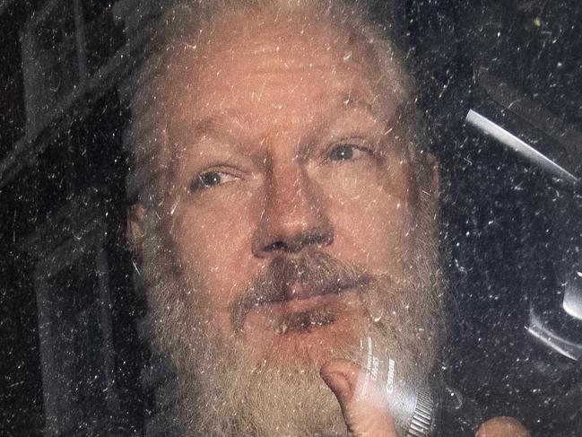 Julian Assange gestures as he arrives at Westminster Magistrates' Court in London, after the WikiLeaks founder was arrested by officers from the Metropolitan Police and taken into custody Thursday April 11, 2019. Police in London arrested WikiLeaks founder Assange at the Ecuadorean embassy Thursday for failing to surrender to the court in 2012, shortly after the South American nation revoked his asylum .(Victoria Jones/PA via AP)