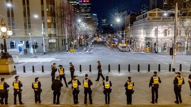 Police officers patrol Melbourne’s CBD on Monday night before a new curfew and COVID restrictions come into place. Picture: David Geraghty