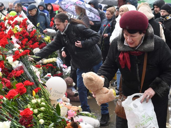 A woman places a Teddy bear at a makeshift memorial in front of the Crocus City Hall in Krasnogorsk. Picture: AFP