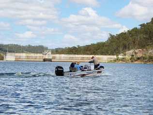 FRESH STOCKS: Members of the fish stocking association prepare to release Australian Bass fingerlings on the far side of Lake Manchester. Picture: Contributed