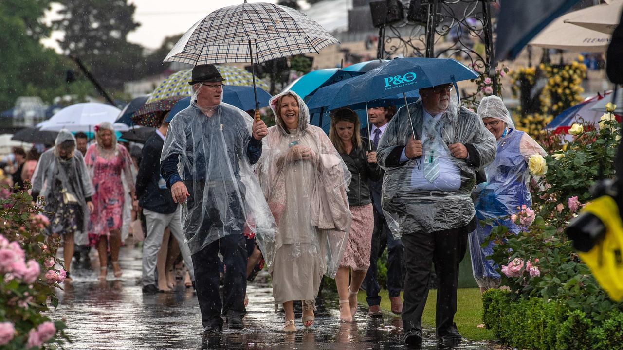 2018 Melbourne Cup, Punters arrive in the rain at Flemington. Heavy rain hits Flemington. Picture: Jason Edwards