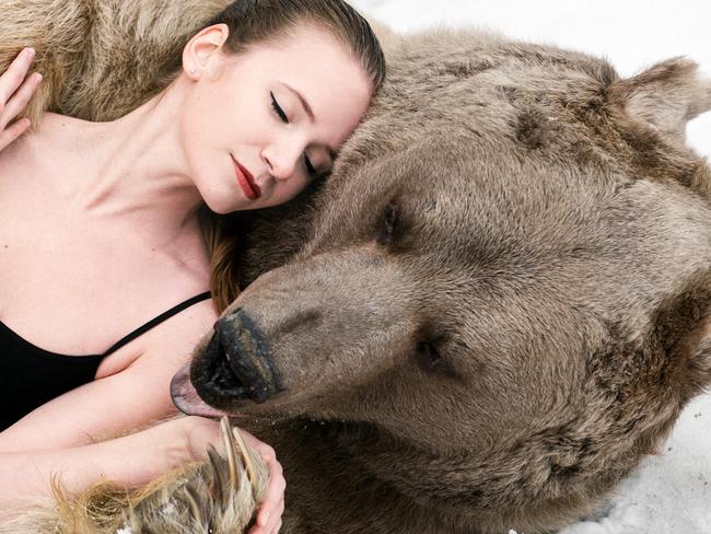 PIC BY OLGA BARANTSEVA/ CATERS NEWS - (PICTURED: Lidia Fetisova modelling with Stephen the bear) - Two scantily clad models pose with a giant brown bear - in a bizarre bid to raise awareness about the ferocious predators softer side. The strange scenes were pictured in a forest outside of Moscow, Russia, and have gone viral in the country. The series of photos show two models - Maria Sidorova and Lidia Fetisova - hugging, cuddling and kissing the 650kg bear, named Stephen. Photographer Olga Barantseva, who captured the dream-like series of snaps, said: We wanted to show the natural harmony between humans and bears. SEE CATERS COPY.