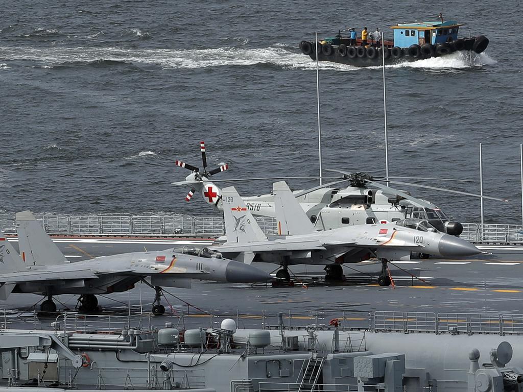 Fighter jets and a helicopter sit on the deck of China's first aircraft carrier the Liaoning. Picture: AP