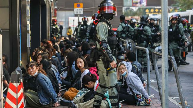 People are detained by police near the Hong Kong Polytechnic University in Hung Hom district on Monday. Picture: AFP