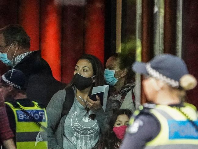 Recently arrived overseas travellers get off their bus and wait to check in at the Crown Promenade Hotel in Melbourne. Picture: AAPe,