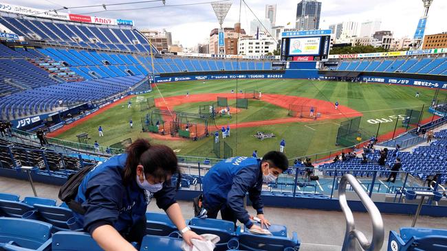 Workers cleaning seats of the Yokohama Stadium, which will host baseball and softball games during the Games. Picture: AFP