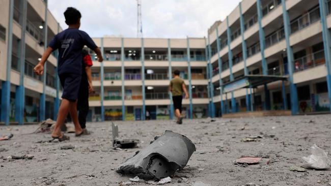 Palestian children walks past debris in the courtyard of a school run by the United Nations Relief and Works Agency for Palestine refugees. Picture: AFP