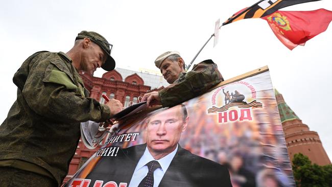 Activists hold a portrait of Russian President Vladimir Putin near Red Square in Moscow, on Saturday. Picture: AFP