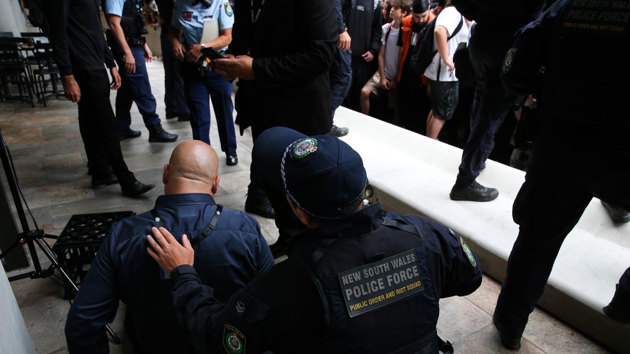 Police are seen attending to a security man as the crowds of Fans surged forward forcing the cement wall to come down as Logan Paul stepped out onto the balcony, at the Today Show Studios in North Sydney. Picture: NCA Newswire/ Gaye Gerard