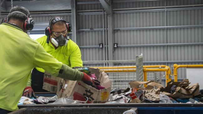 Workers at the new Cairns Regional Council Portsmith Materials Recovery Facility remove contaminated materials from collected kerbside waste before a hi-tech separation process. Picture: Brian Cassey