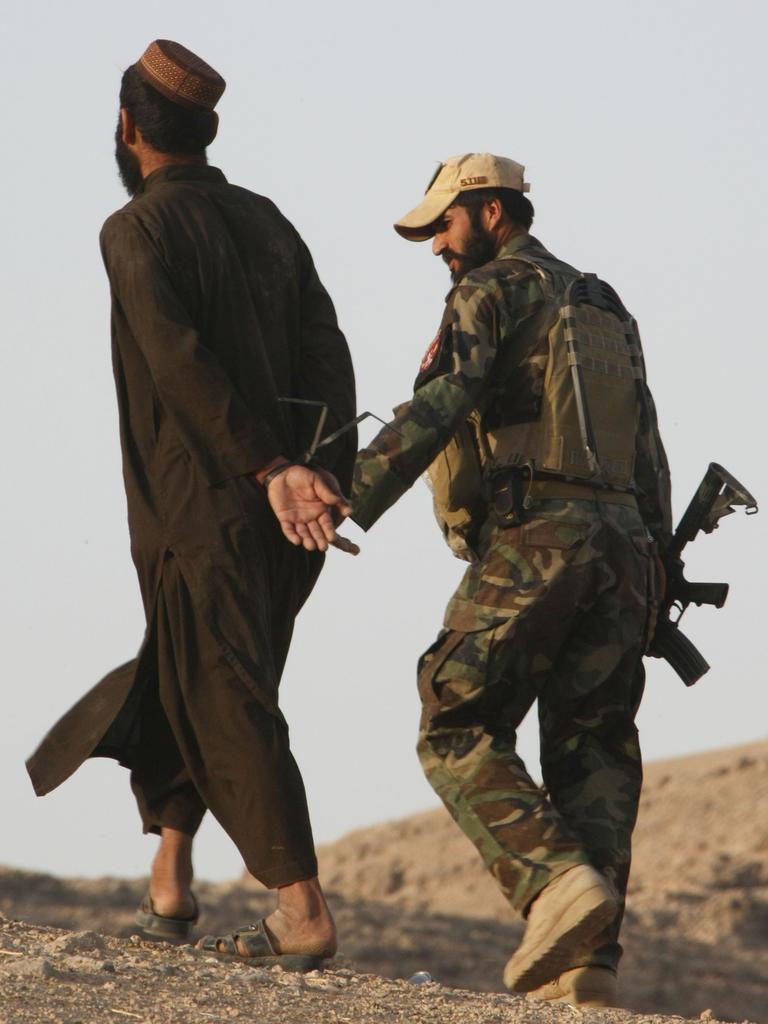 An Afghan National Army Special Forces Commando (ANASF) brings in a local Afghan man for questioning during a recent partnered ANASF and Australian SF operation to clear a township of Taliban fighters in Uruzgan Province.