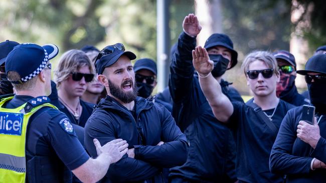 Stop Immigration Rally. National Socialist Network Neo-Nazis protest against a proposed increase to immigration. Campaign Against Racism and Fascism coalition stage a counter protest at State Parliament. Thomas Sewell speaks with police while members display the nazi salute. Picture: Jake Nowakowski