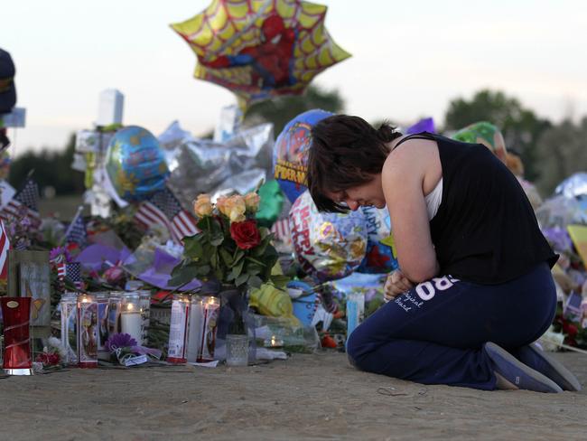 Ashleigh Grove grieves over the lost of her friend Micayla Medek at the makeshift memorial for the 12 cinema shooting victims across from the Century 16 Theatre in Aurora, Colorado. Picture: Joshua Lott