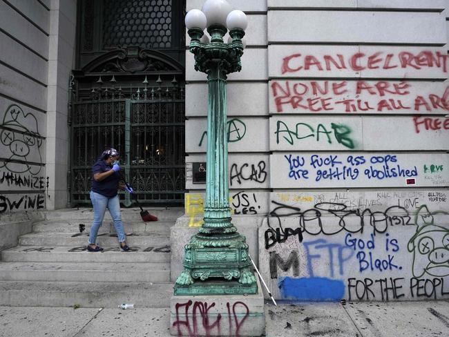 A city worker cleans up the street in front of a New York City government building across the street from the Black Lives Matter protesters, as they congregate at City Hall. Picture: AFP