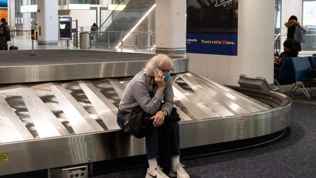 A traveller sits in baggage claim at LaGuardia Airport in New York. Picture: AFP