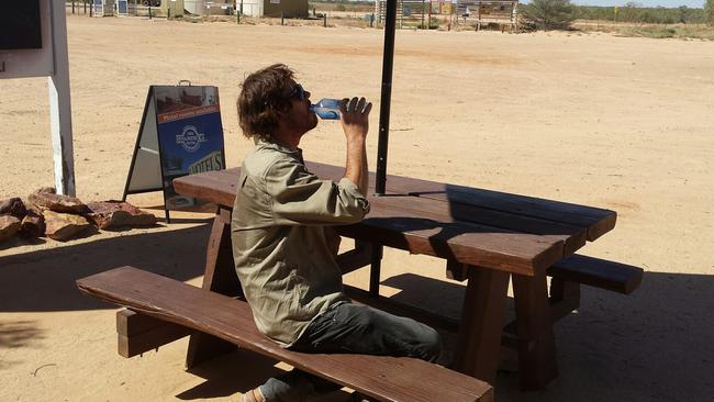 John Willoughby cools down with a cold bottle of water. Picture: Nichelle Hodgson, manager of the Innamincka Hotel