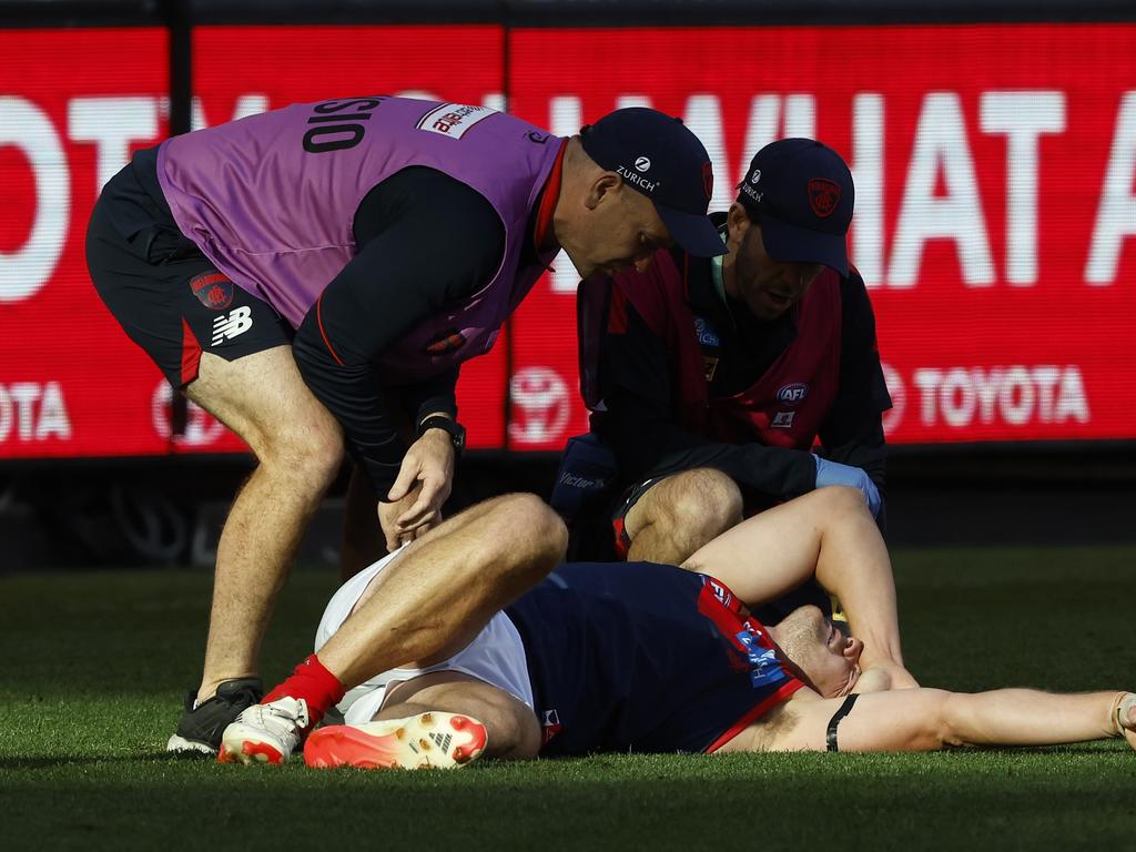 Steven May of the Demons is helped by trainers after a heavy collision at the MCG. Picture: Darrian Traynor/Getty Images.