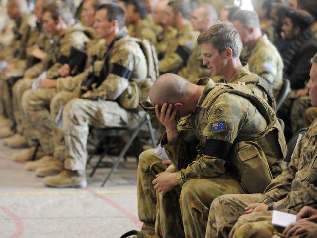 LARGE FILES. TOWNSVILLE TROOPS IN AFGHANISTAN OCTOBER 2011. Service and ramp ceremony at Tarin Kot, Uruzgan Province Afghanistan for three Australian soldiers CAPT Bryce Duffy, CPL Ashley Birt and LCPL Luke Gavin. Seated on left is CPL Dale Birt and seated on the right with shaved head is Cpl Michael Giannoukas (spelling correct) a friend of deceased digger Cpl Ashley Birt, during the service. Picture Evan Morgan
