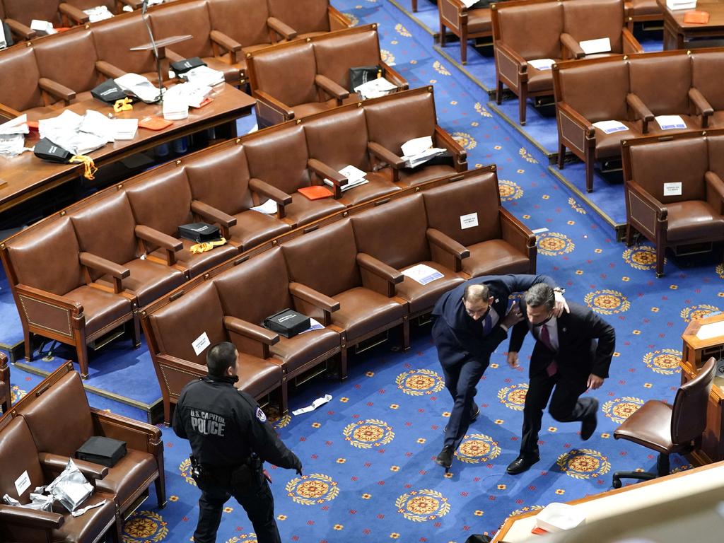 Members of congress run for cover as protesters try to enter the House Chamber during a joint session of Congress. Picture: Getty