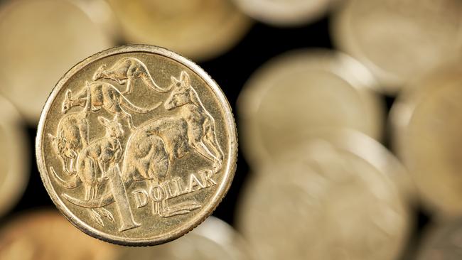 Australian one dollar coin over blurred golden background.