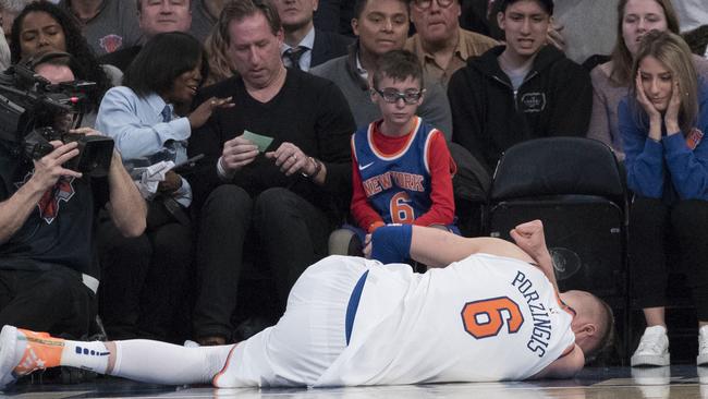 New York Knicks forward Kristaps Porzingis lies on the ground.