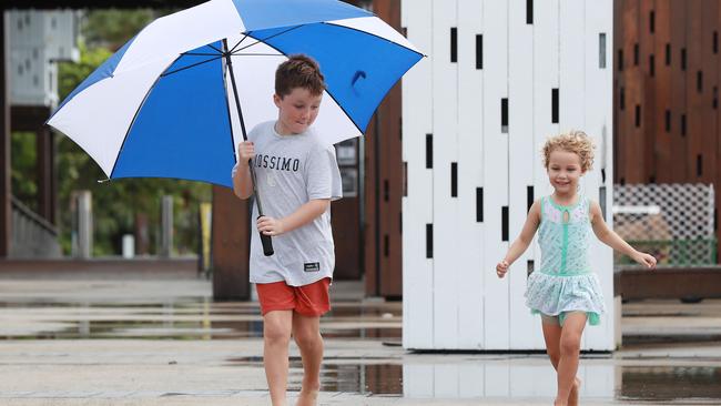 Wet weather is predicted for Cairns this week. Micah Stone, 8, and his sister Vi Stone, 4, run barefoot through the puddles near the Cairns Wharf. Picture: Brendan Radke